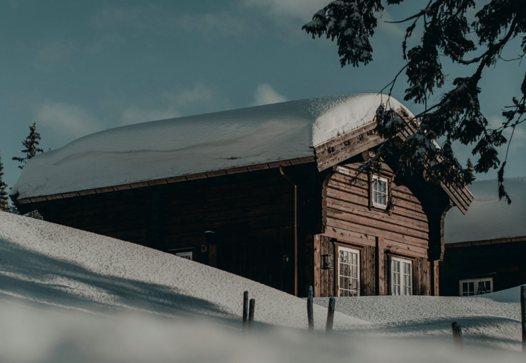 Chalet traditionnel en bois sous une épaisse couche de neige